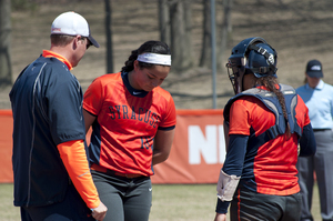 Syracuse pitcher Jocelyn Cater receives a mound visit from assistant coach Mike Bosch and catcher Julie Wambold.