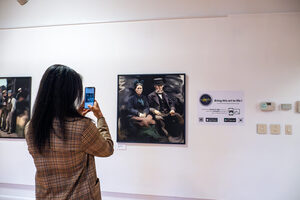 Gallery guests freely browse and capture Jalen Law's exhibition Unveiled Echoes, which features archived newspaper clippings and his original artwork. According to the exhibit description, Law has been making art since age four. 