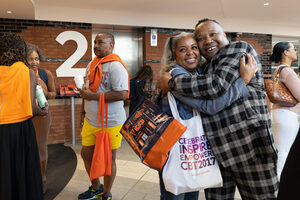 Alumni reunite during Syracuse University’s Coming Back Together event at the Schine Student Center. The two old friends share a warm embrace.