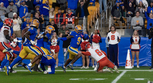 Syracuse quarterback Kyle McCord (pictured, No. 6) falls to the ground attempting to tackle Pitt linebacker Kyle Louis (pictured, No. 9) after an interception. Louis tallied a 59-yard pick-six, one of three interceptions returned for a touchdown against McCord.