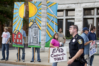 Occupy supporters watch an SPD officer at a protest at City Hall.