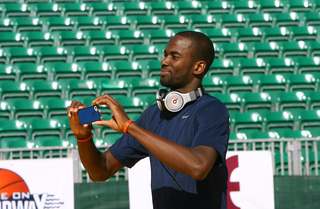 Baye Moussa Keita takes a picture on his iPhone on the court during media day on Nov. 10, 2012 before Sunday's Battle on the Midway game against the San Diego State Aztecs aboard the USS Midway