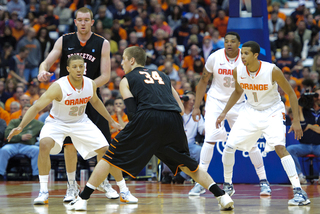 Syracuse's 2-3 zone defense, led by Brandon Triche (20) and Michael Carter-Williams (1) at guard, sets itself up in place as Ian Hummer holds the ball at the top of the arc.