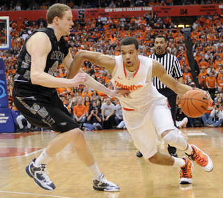 Michael Carter-Williams drives past Nate Lubick.