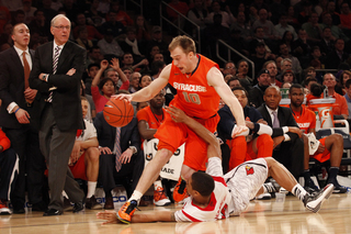 Trevor Cooney drives the ball over Louisville's Wayne Blackshear (#20).