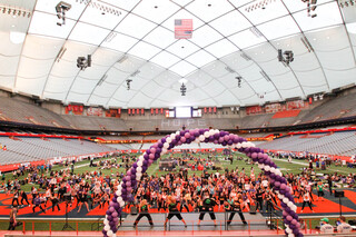 Participants at Relay For Life gather around the stage as student groups perform during the event.